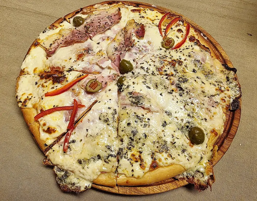 Pizza entera mitad roquefort y mitad especial con jamón y morrones